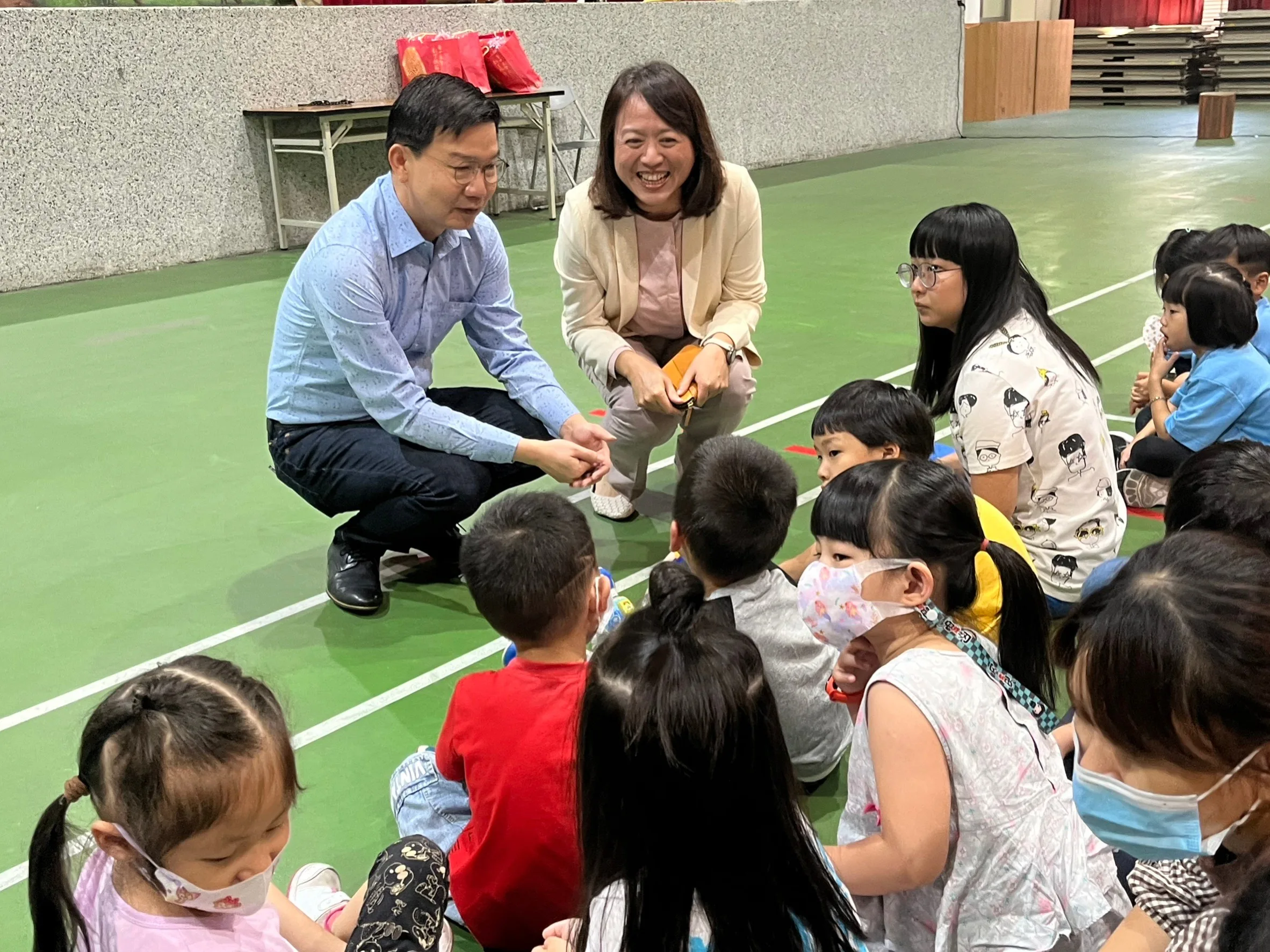 臺中客委會主委江俊龍與東勢國小校長林方鈴一同跟孩童互動。臺中市客委會提供