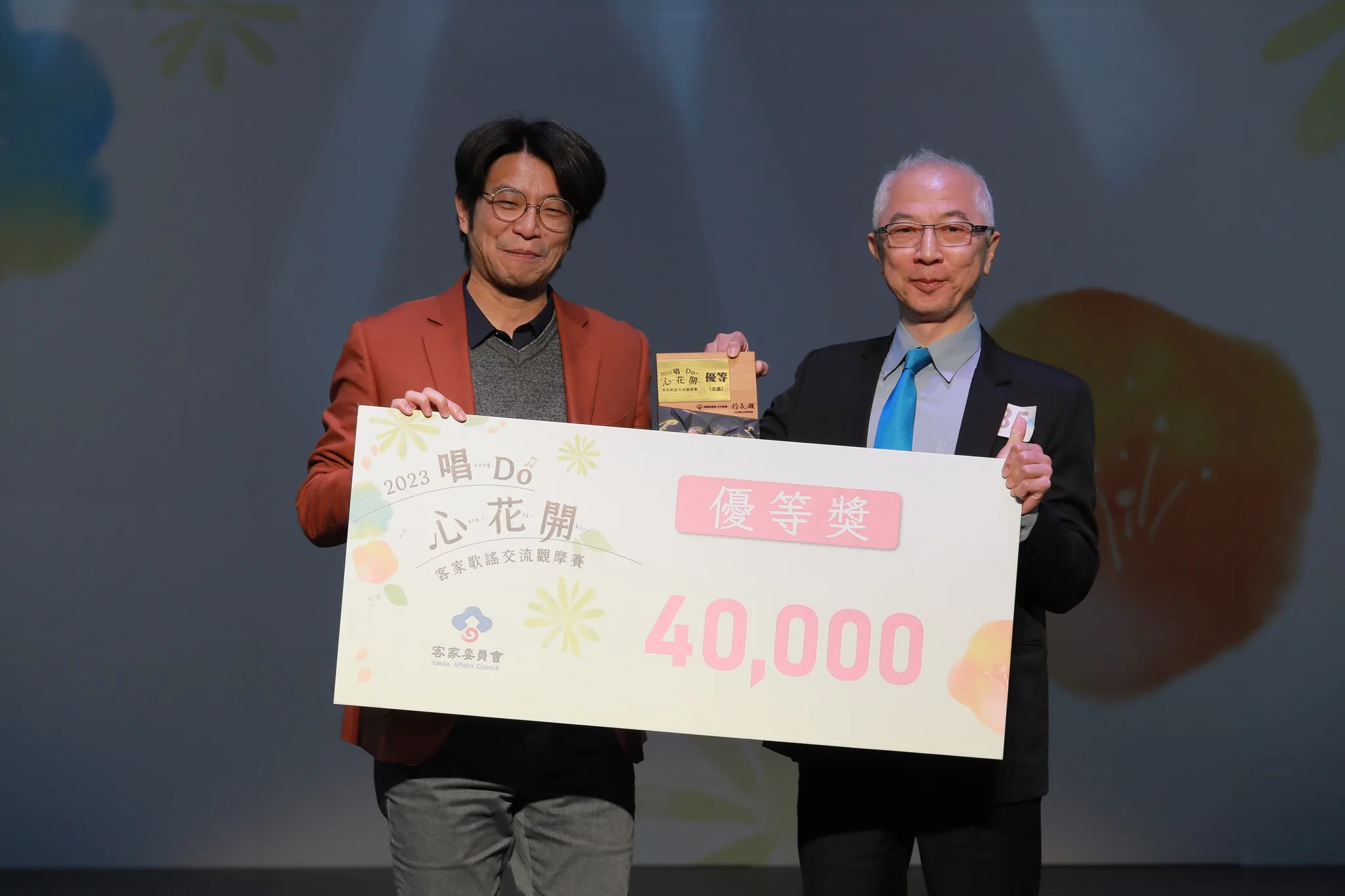 台北客家鄉音合唱團（客家歌謠混聲合唱研習班）獲得今年客家歌謠交流觀摩賽北區優等大獎，左為頒獎人客委會副主委周江杰。客委會提供