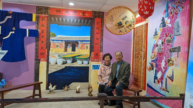 賴江椿、陳登美夫婦在休士頓華僑文教服務中心佈置的「客家大院」留影。賴江椿提供