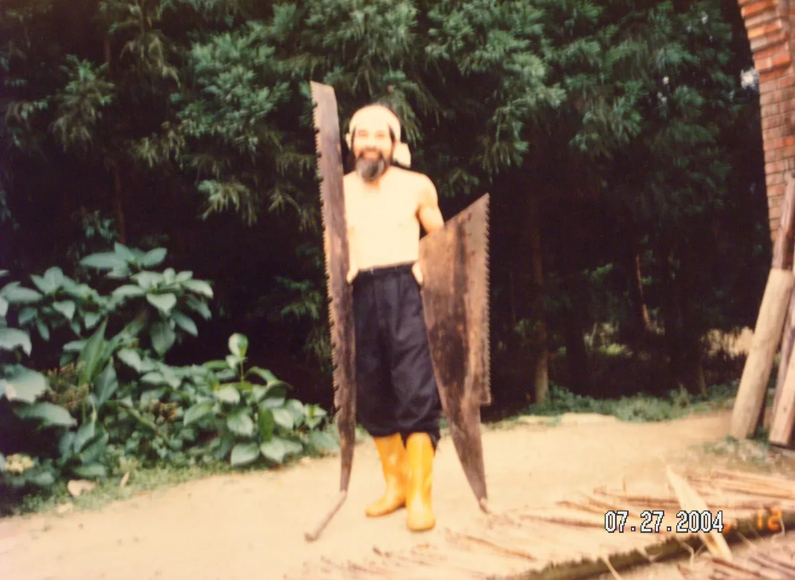 范阿欽曾是八仙山伐木工人,依賴特大型鋸子,且需特殊技巧與力道,圖為他生前與特大型鋸子合影。范振乾提供