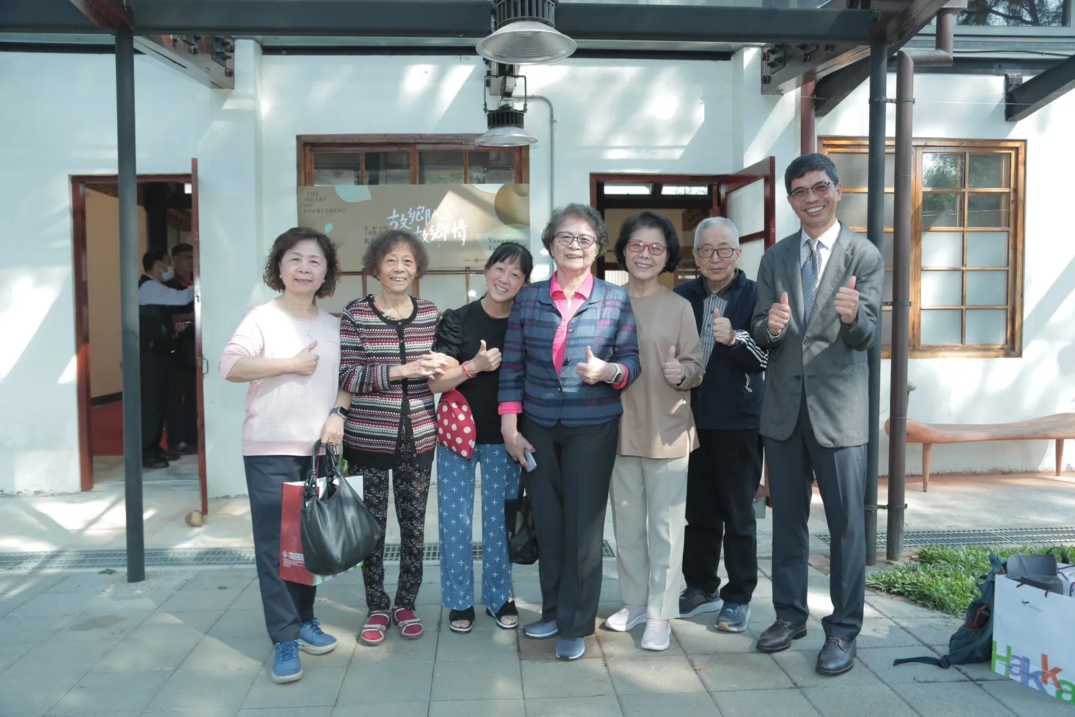 黃娟妹妹黃惠信（中）、黃壽美（右三）賢伉儷、張芳杰校長女兒張琪玲（左一）等人與客發中心主任何金樑合影留念（右一）。客發中心提供