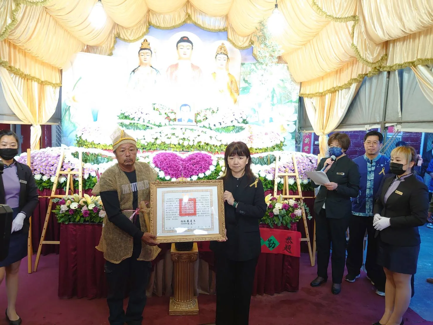 文化部次長李靜慧(右)代表總統蔡英文頒發總統褒揚令予鍾雲輝長子鍾貴榮(左),以表哀思及敬意。客委會提供