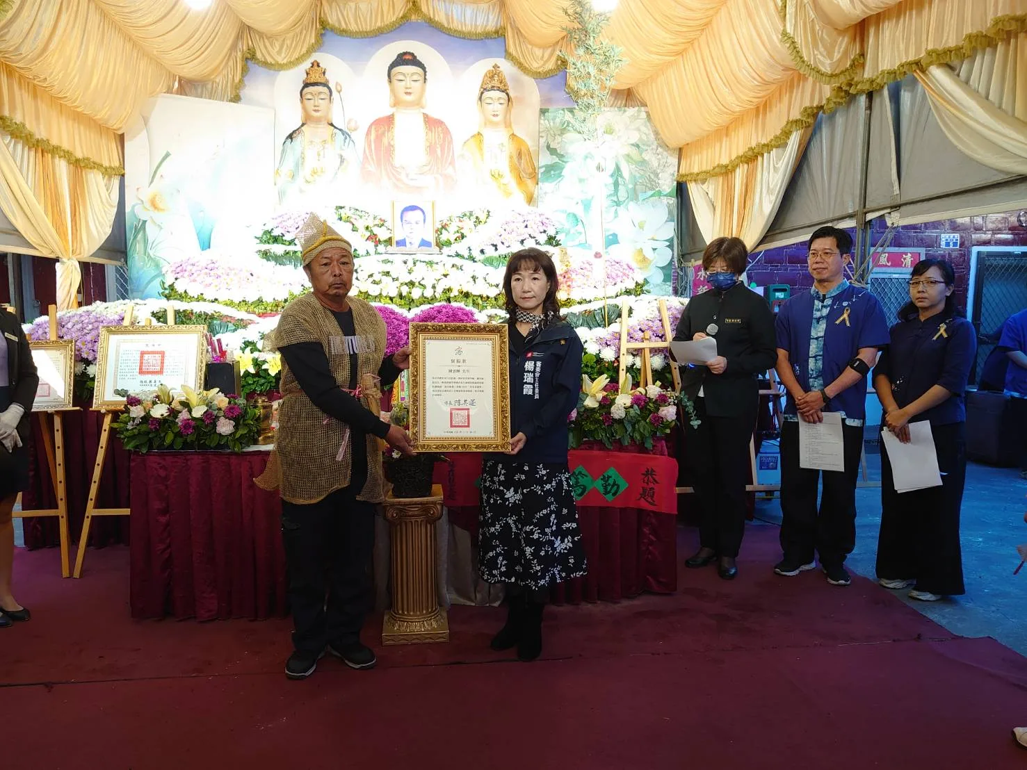 高雄市政府客家事務委員會主任委員楊瑞霞(右)頒贈褒揚狀予鍾雲輝長子鍾貴榮(左),以表哀思及敬意。客委會提供
