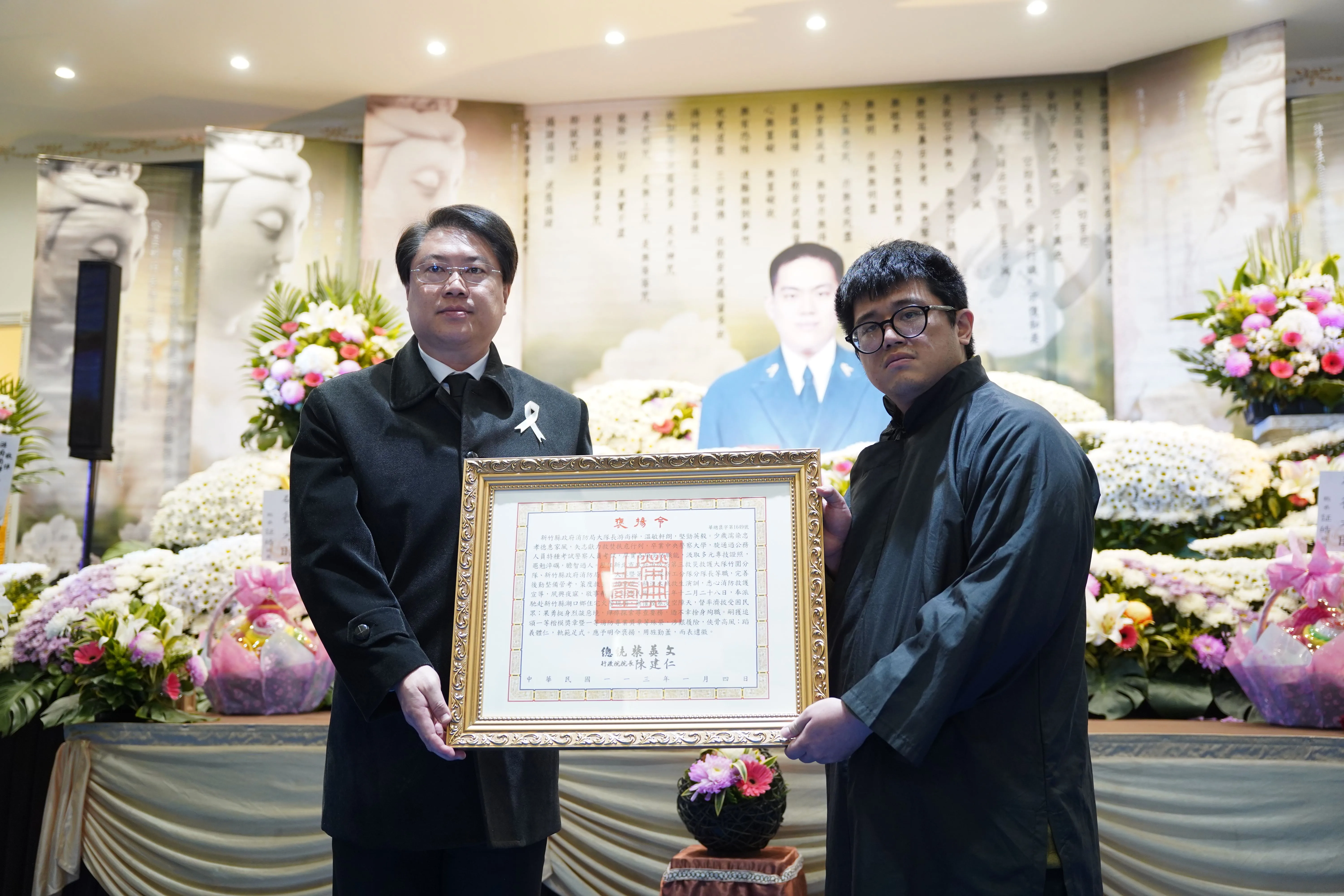 內政部長林右昌（左）代表頒發總統府褒揚令。