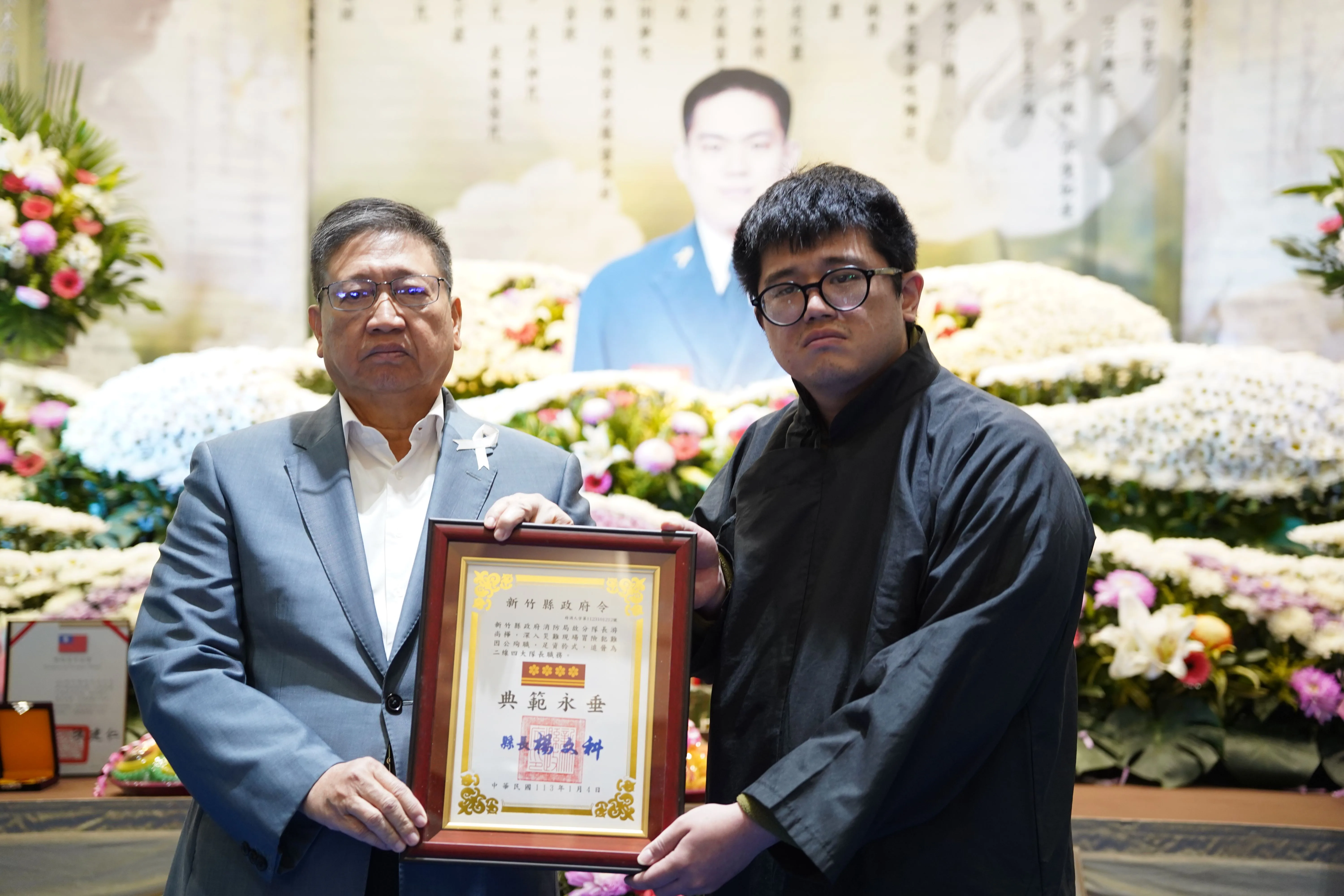 新竹縣長楊文科頒贈追晉游尚樺為大隊長的追晉令。