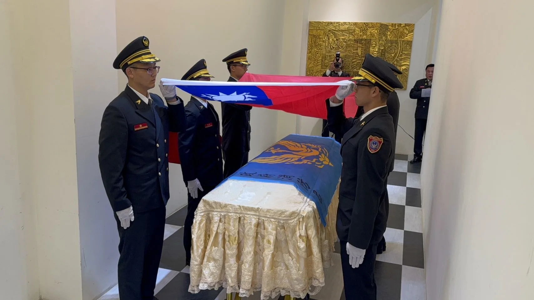 告別式現場，由消防局同仁將消防旗和國旗覆蓋於游尚樺的靈柩上，以最高榮譽致敬其英勇精神。（民眾提供）