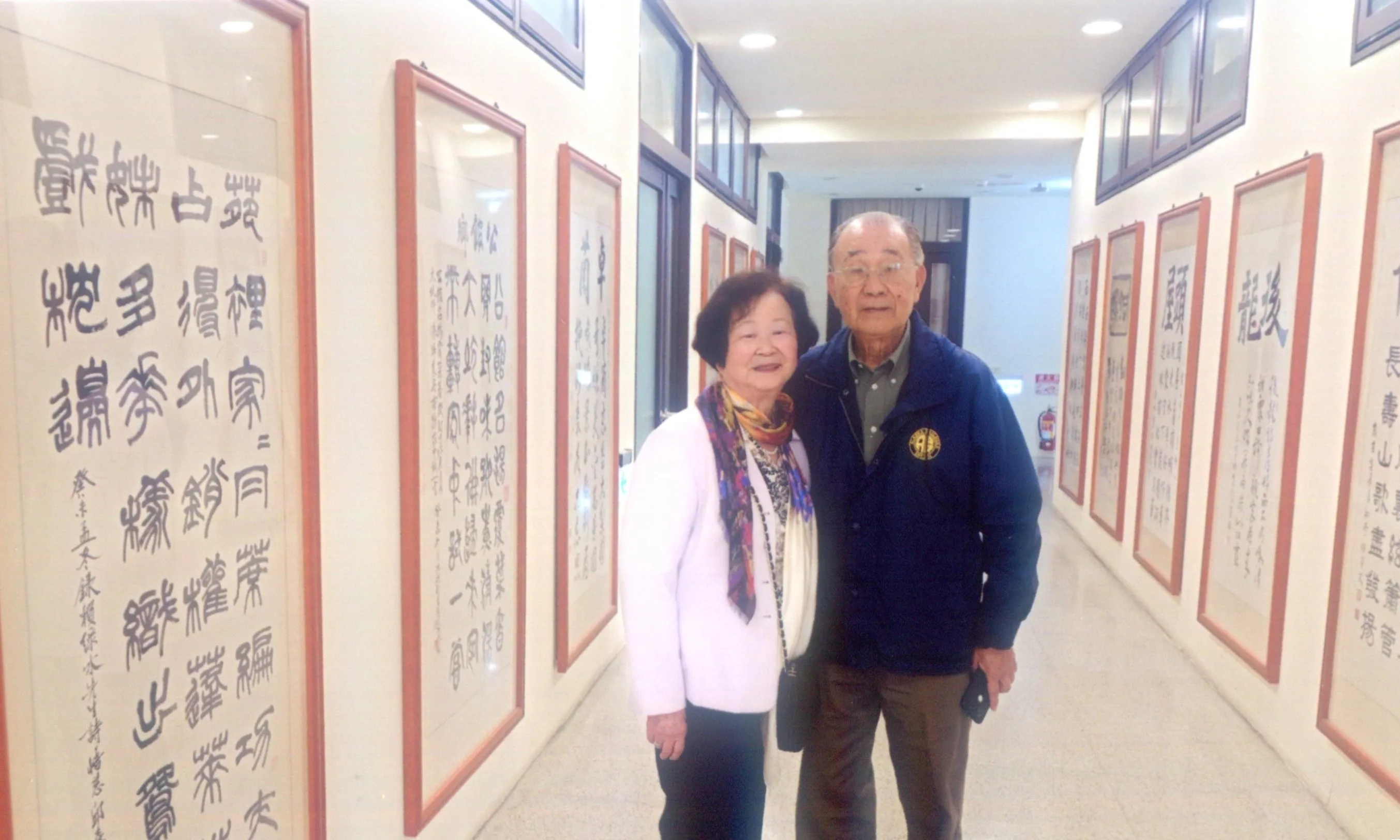 賴江椿、陳登美夫婦到聯合大學國鼎圖書館七樓走廊，參觀父親賴江質所作的「十八鄉鎮詩」，這些詩作由縣內書法家聯合書寫展示。何來美攝