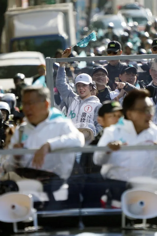 民眾黨副總統候選人吳欣盈(中,舉旗者)11日與民眾黨總統候選人柯文哲(前左)在台北市大直地區車隊掃街,呼籲支持者集中選票。中央社