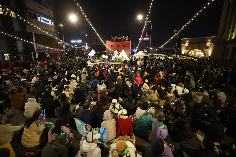 由支持者自主發起的「扛阿北守台灣」感恩守夜晚會11日晚間在台北市北門廣場舉行,吸引不少民眾黨支持者到場,頭戴小草髮飾表達對總統候選人柯文哲的力挺。中央社