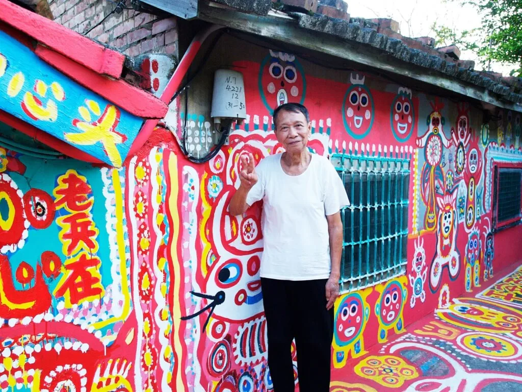 圖為2012年「彩虹爺爺」黃永阜在彩虹眷村拍照。（圖取自facebook.com/rainbow.village）