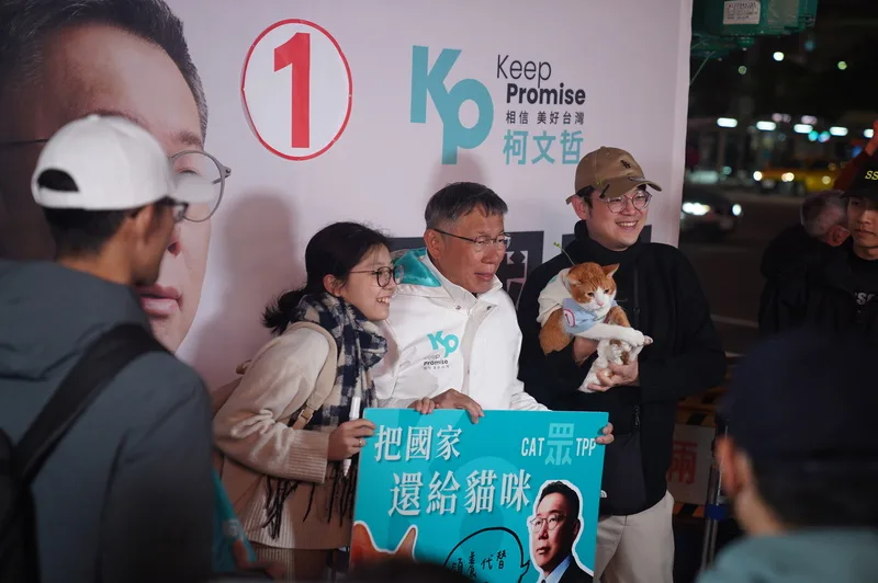 選戰倒數力拚選情,台灣民眾黨總統候選人柯文哲(中)11日晚間在西門町商圈與支持者合影,有民眾特別帶著寵物貓與宣導標語到場相挺。中央社