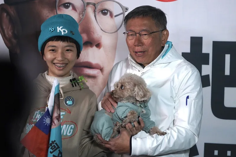 台灣民眾黨總統候選人柯文哲(右)選前2天持續衝選情,11日晚間在西門町商圈與支持者合影,有民眾帶著狗狗一同拍照留念。中央社