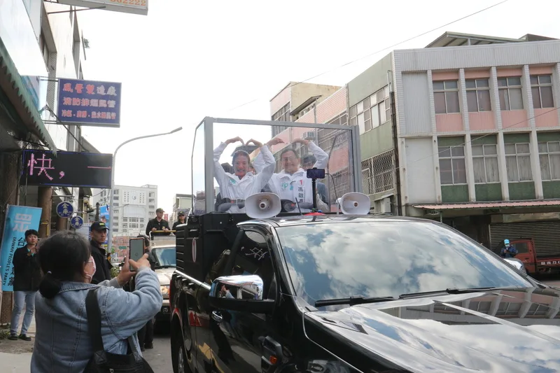 台灣民眾黨副總統候選人吳欣盈（車上前左）8日到苗栗進行車隊掃街拜票，沿途看到支持者為她加油，也高舉雙手比出愛心手勢回應，展現親和力。<br />中央社