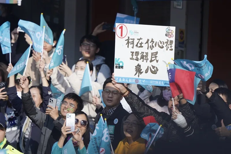 台灣民眾黨正副總統候選人柯文哲與吳欣盈11日在台北市車隊掃街拜票,支持者在內湖區路口舉標語力挺。中央社