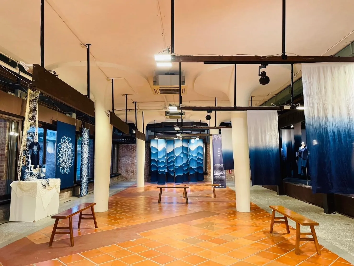 藍染作品襯托出園區磚造建築古樸之美。臺中市客委會提供