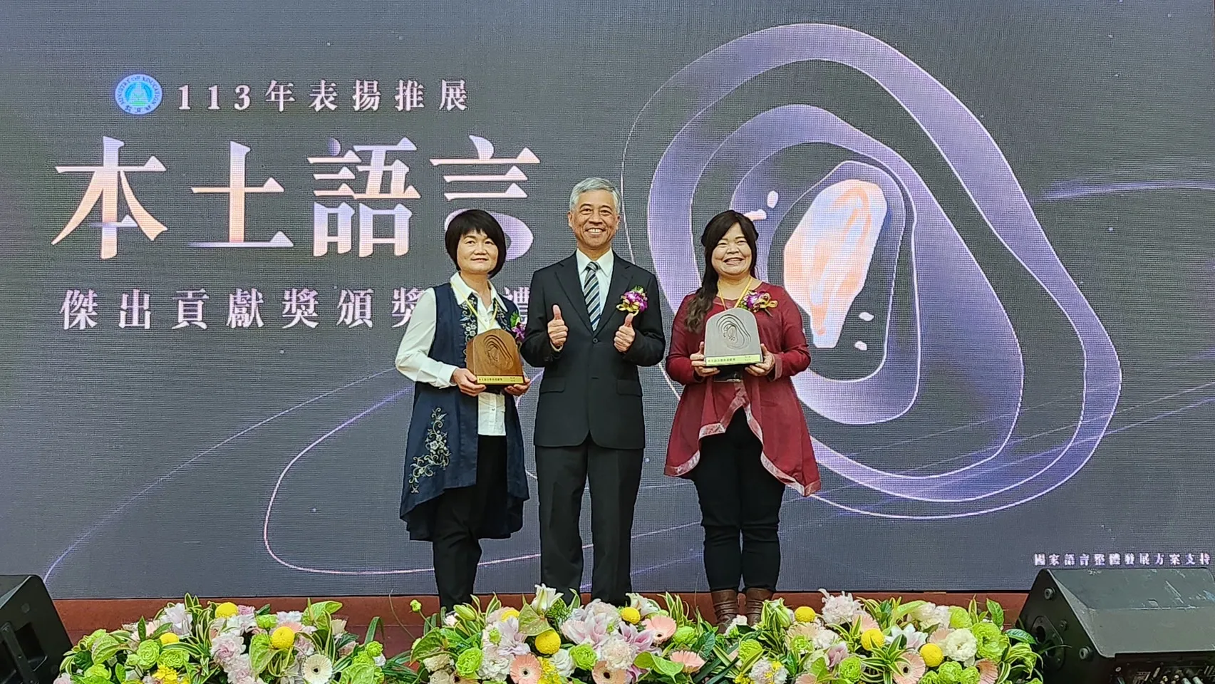客委會范佐銘副主委(中)頒發個人獎,李幸妃教師(左)與彭歲玲委員(右)。教育部提供