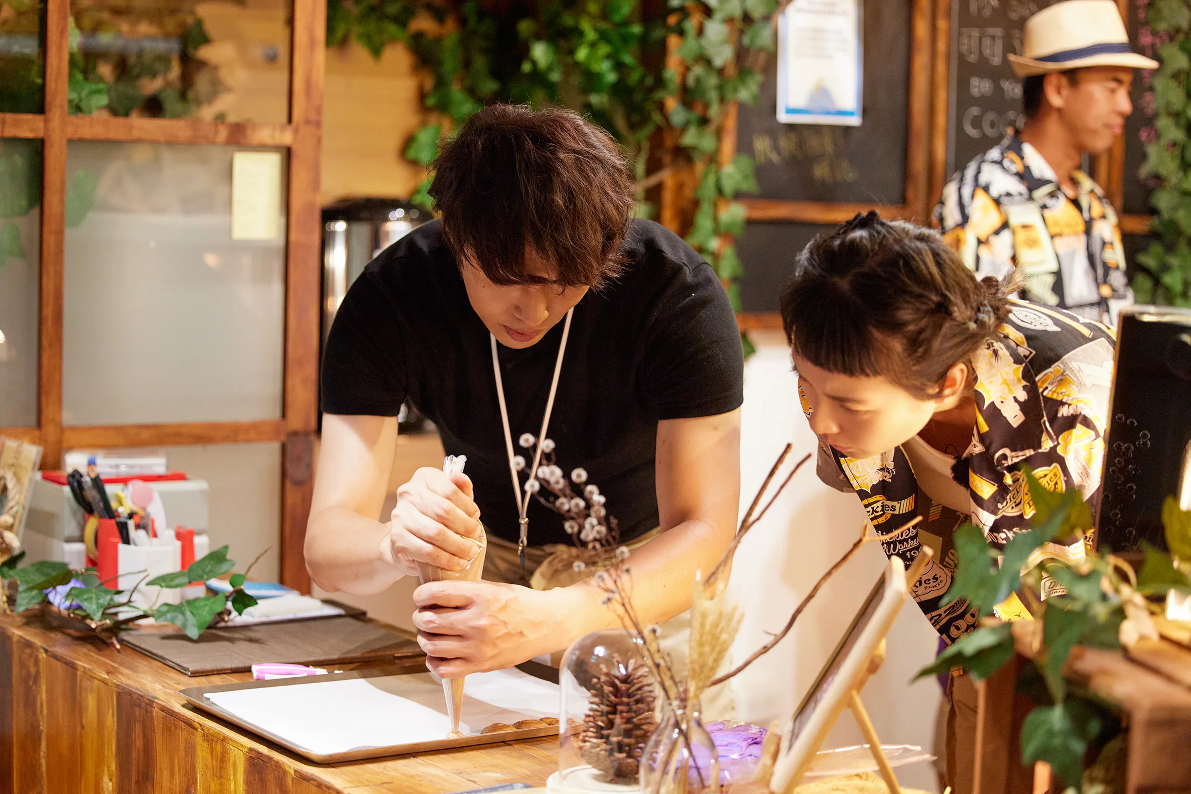 《可可樹下的奇幻小店》甜點指導江舟航老師左）與黃湘婷一起備料。客家電視台提供