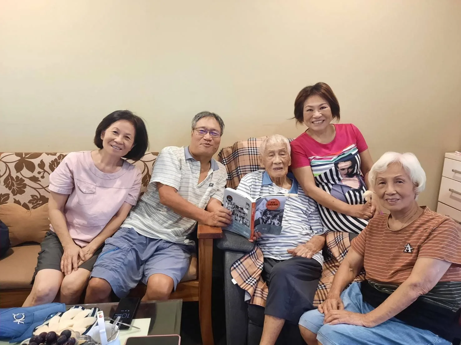 彭啟原（左二）去（2023）年9月親手將剛出爐的新書「「從前從前，有家金淼寫真舘」」，送予99歲的舅舅鄭煥（左三），一旁有其95歲的舅媽（右一）及彭啟原的表妹（右二、左一）陪伴。翻攝自彭啟原臉書