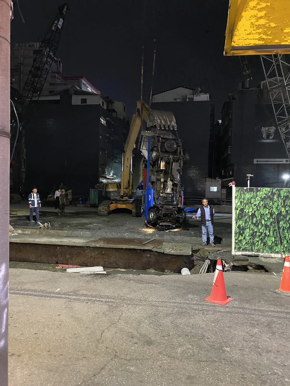 台南一處工地旁道路出現坑洞,現場出動怪手搶救,將車輛從坑洞吊掛出來。台南市政府提供