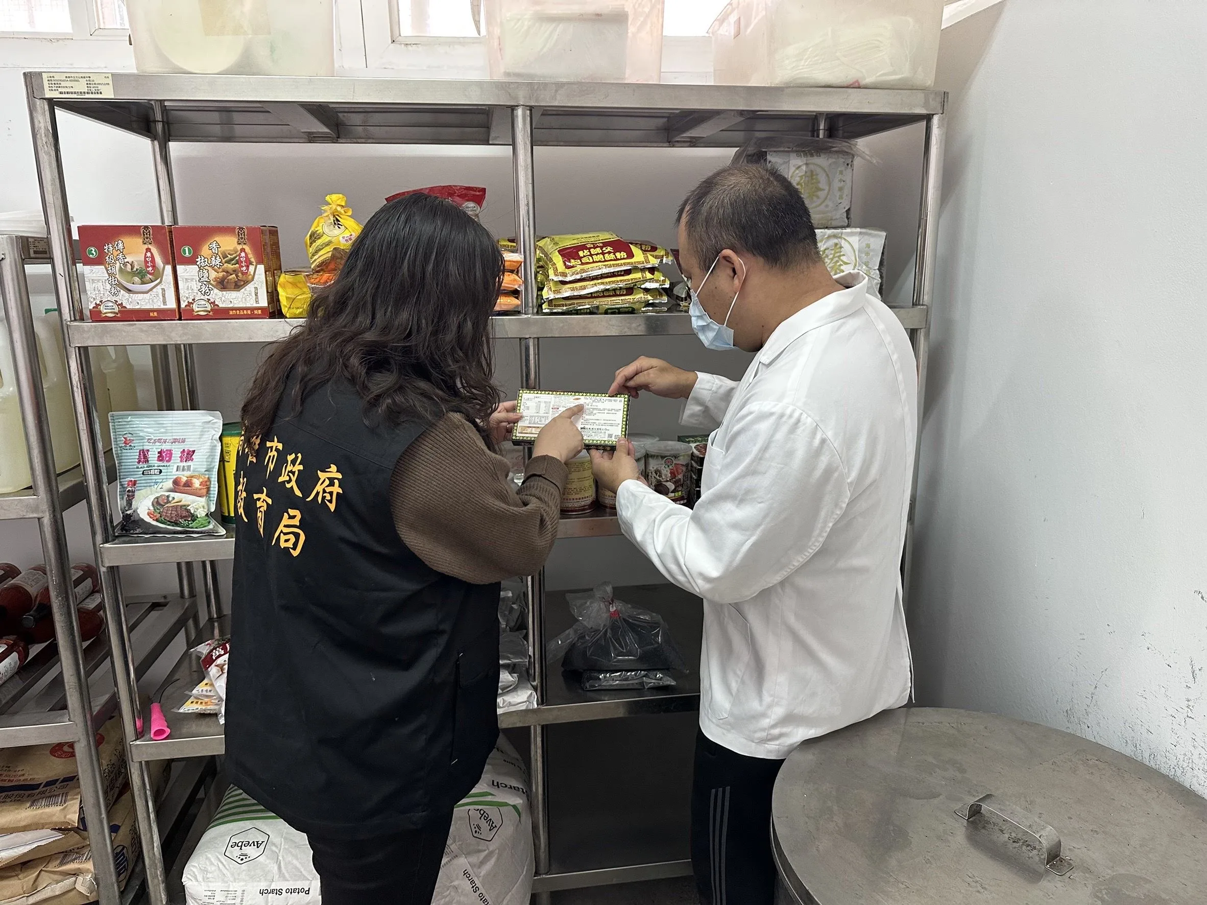 高雄市教育局到校稽查指導學校午餐使用合格調味品。高雄市政府提供