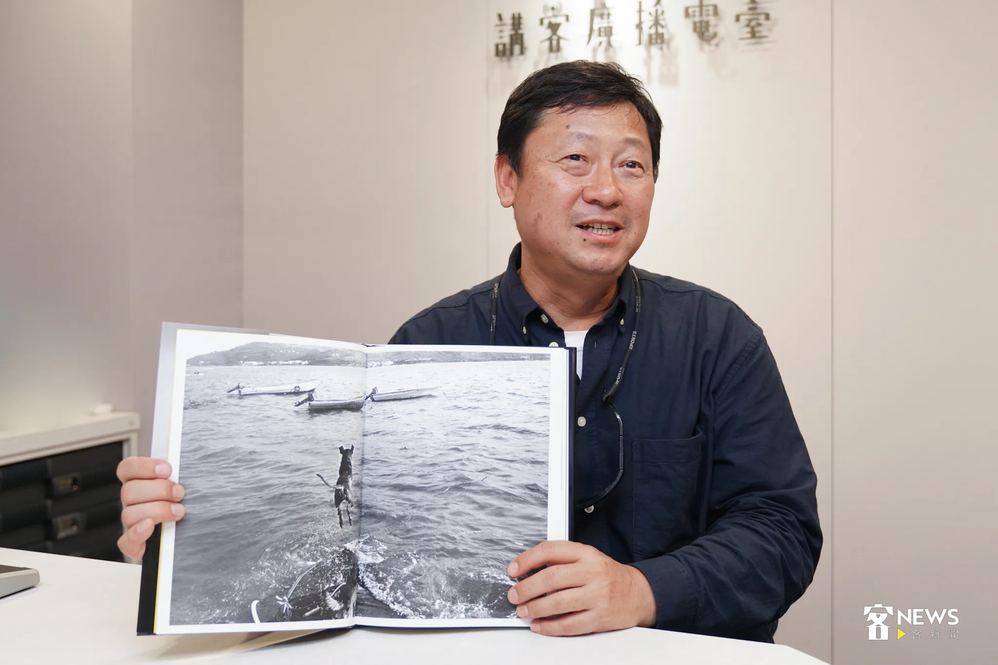 張良一指著攝影集這張照片,他說,跳水的小狗完成了他的心願。李台源攝