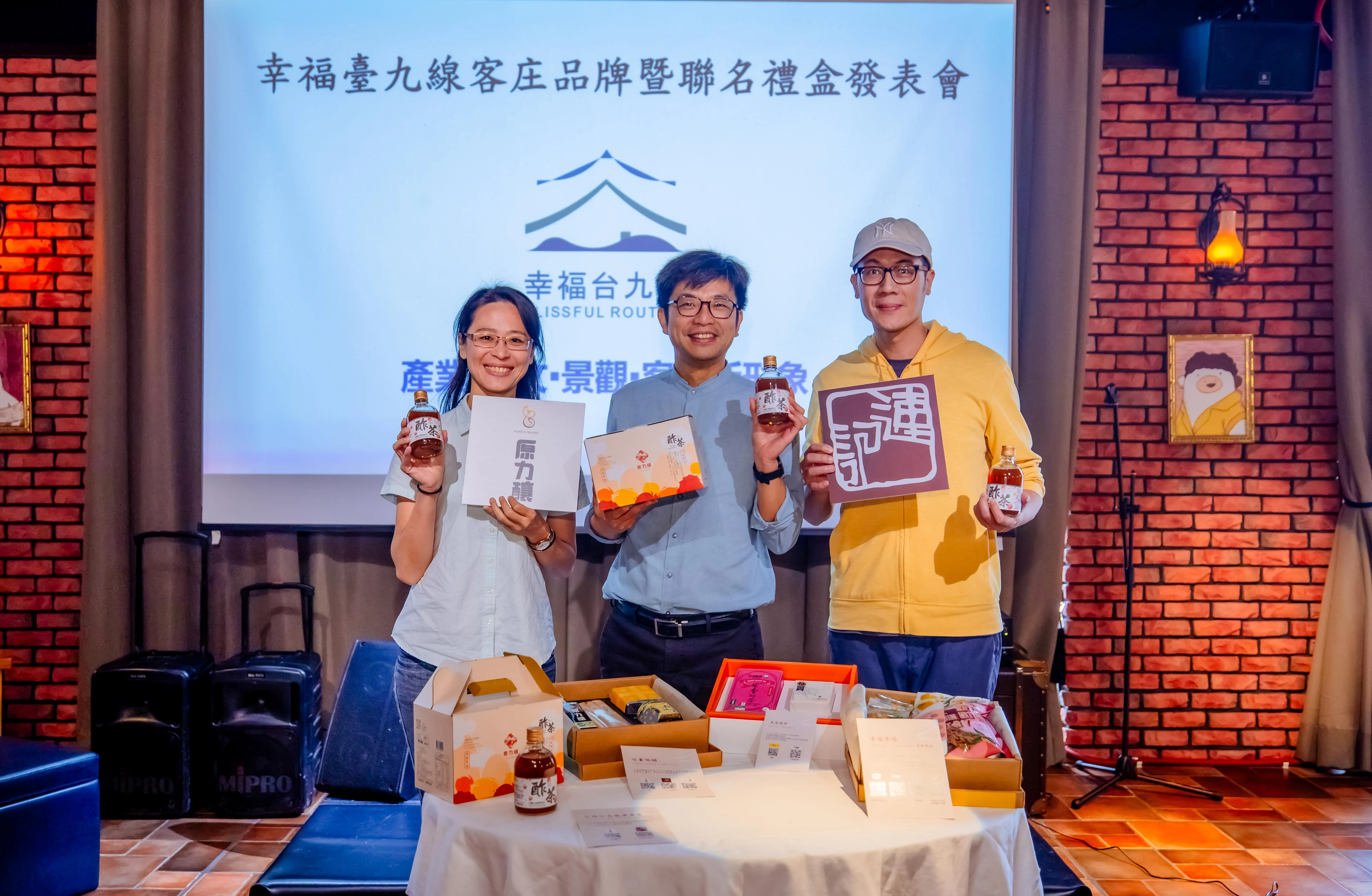 客委會副主委周江杰（中）與合作業者開箱聯名禮盒。客委會提供