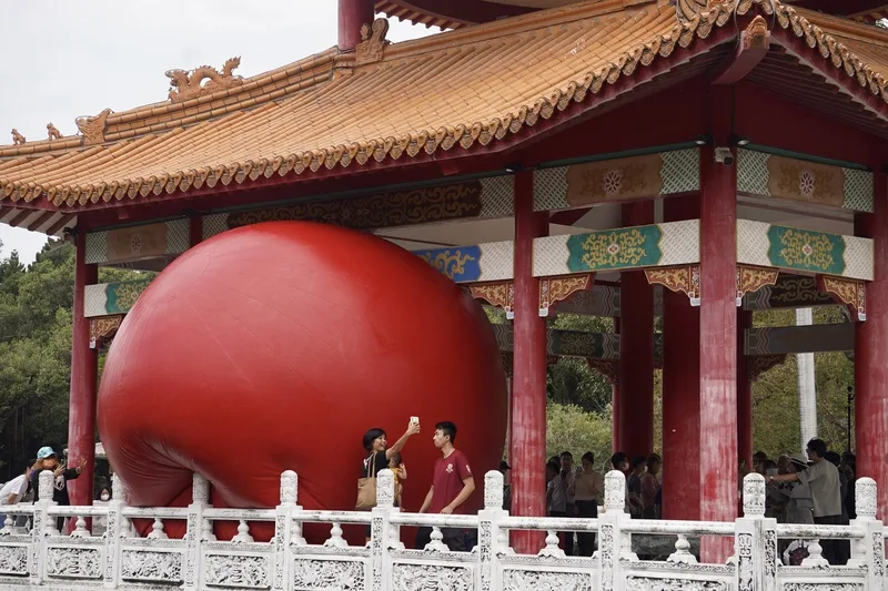 紅球台南歷史街區策展行動31日移展台南公園念慈亭,充氣後在南側臨湖處亮相,吸引許多旅客湧入,拍照留念。中央社