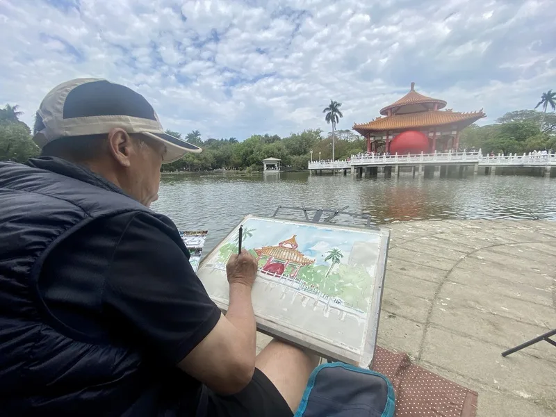紅球台南歷史街區策展行動31日移展台南公園念慈亭,巨大紅球搭配水域景觀吸睛,有民眾在南側臨湖處寫生,希望留下紀念。中央社