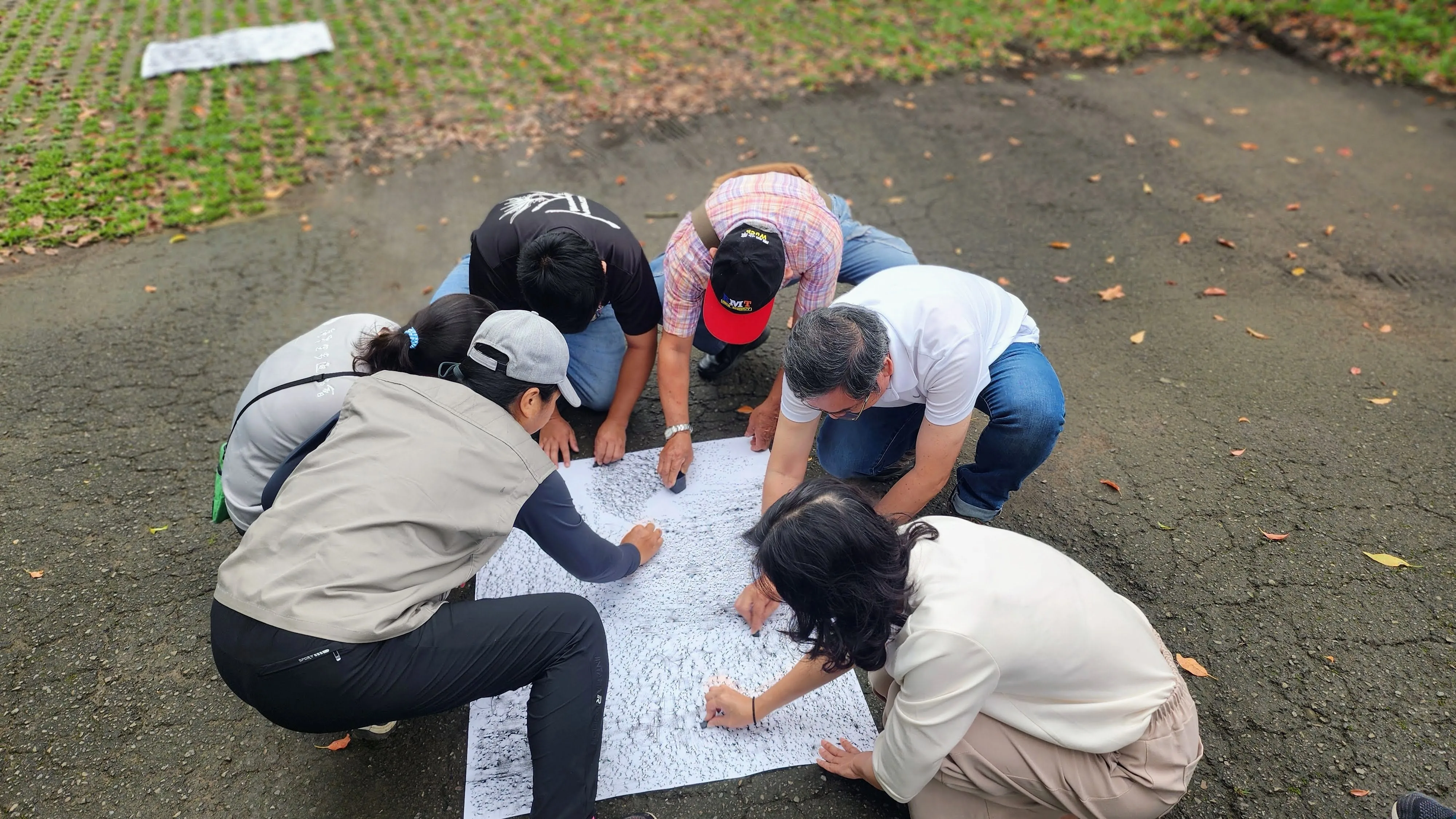 大型紙張拓繪，就必須考驗大家協力、甚至輪流拓繪，也因此是集結眾人觀察力共創的作品，圖為大家共同拓繪破碎柏油路與其上的落葉。（台三線藝術季學校提供）