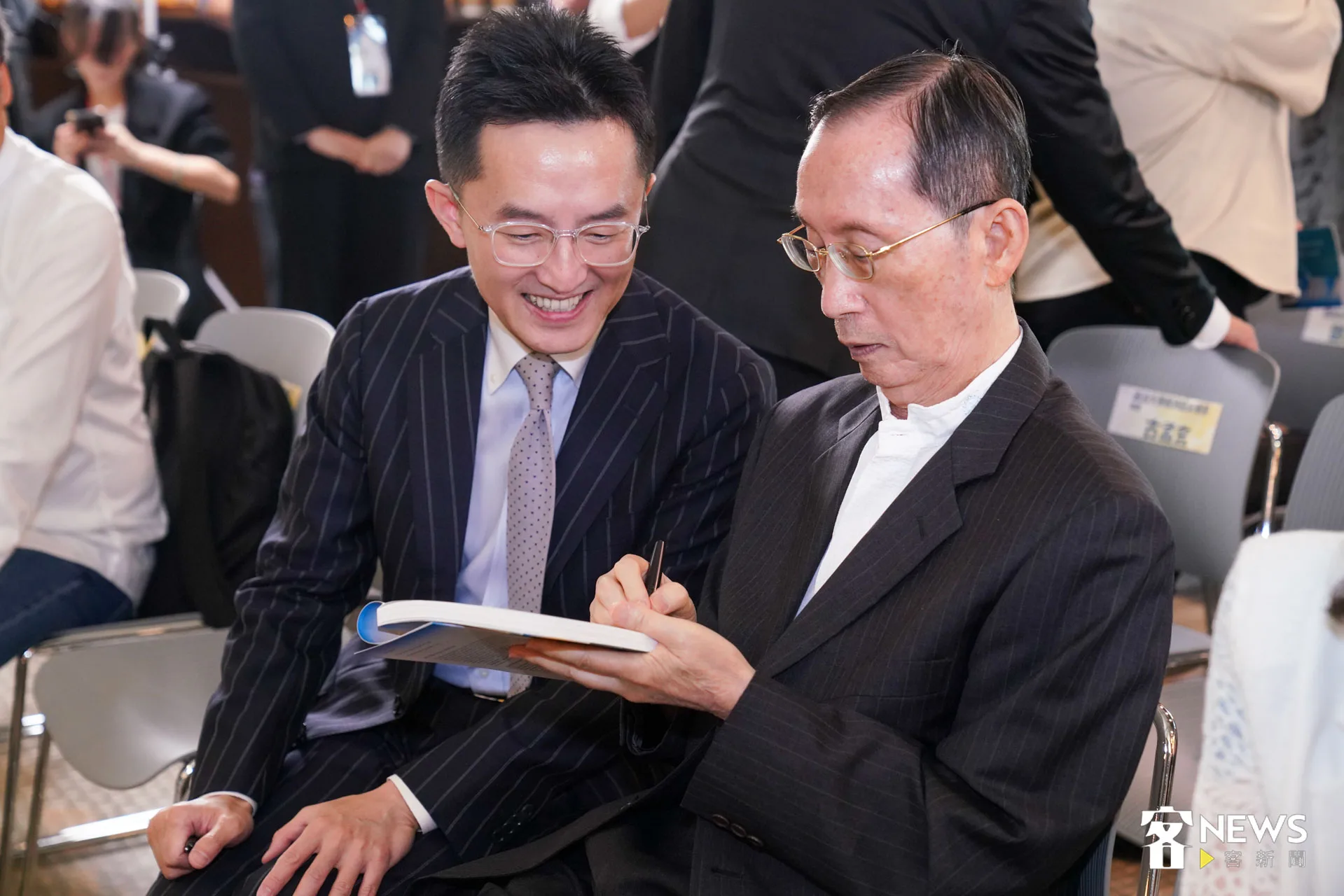 客家電視臺臺長向盛言拿新書請曾貴海簽名。朱愷元攝