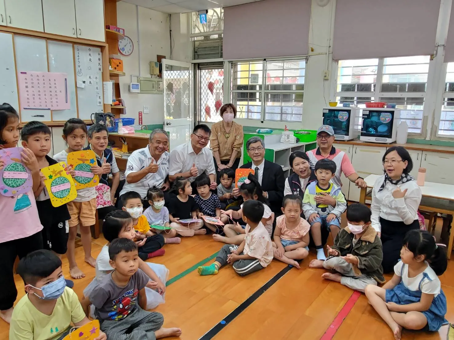 楊長鎮(中穿西裝打領帶者)與客委會語言發展處處長孫于卿(右二後方白衣者)前往雲林縣崙背國小幼兒園訪視生活客語教學情形。客委會提供