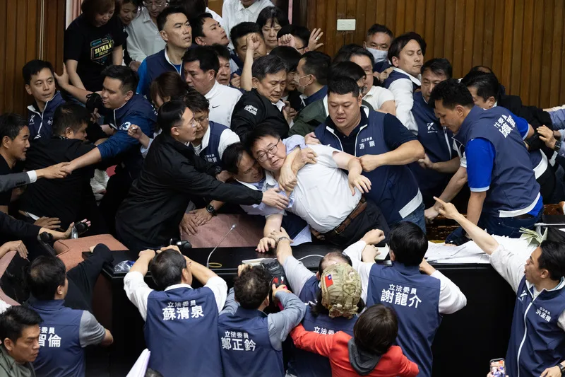 晚間朝野立委再度上演激烈攻防,各方人馬推擠拉扯,民進黨立委吳秉叡(前中白襯衫者)一度勒著脖子。中央社