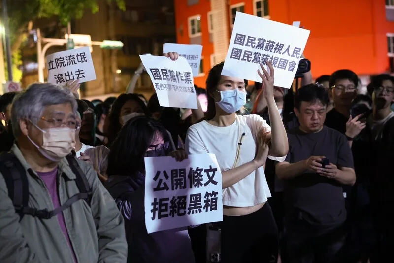 民眾高舉標語呼籲公開法案條文、拒絕黑箱等。中央社