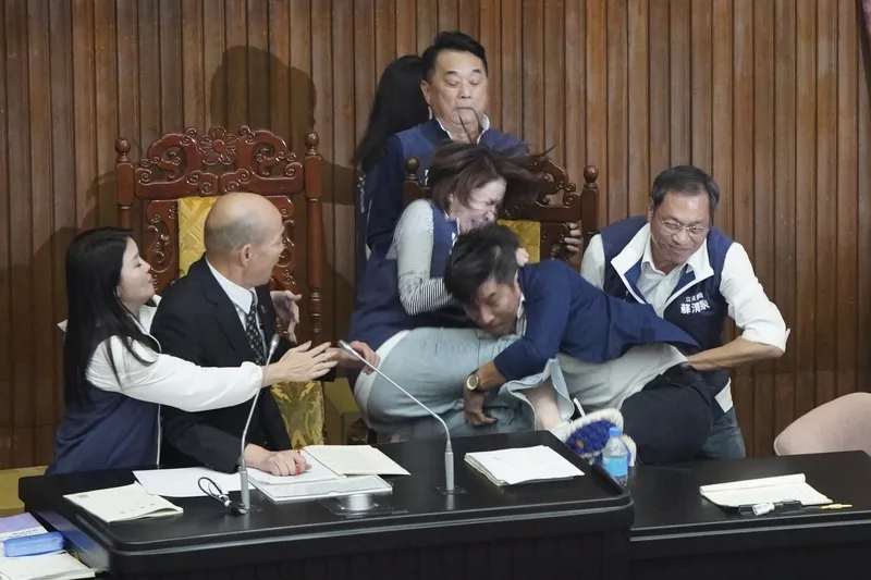 朝野衝突中,圖為民進黨立委鍾佳濱(前右2)衝上主席台時,國民黨立委陳菁徽上前阻擋,鍾佳濱因腳踩到桌上的A4紙往前滑倒,一把抱住陳菁徽雙雙跌下主席台。中央社