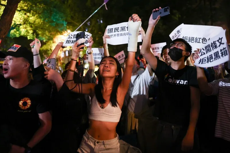 晚間場外群眾聚集表達立場,不少到場民眾激動呼喊口號、揮動手中標語,要求場內停止表決、實質審查。中央社