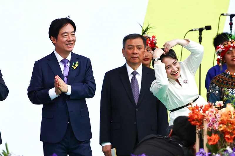 副總統蕭美琴（前右）在大合唱時向民眾及表演團體比愛心。左為總統賴清德。中央社