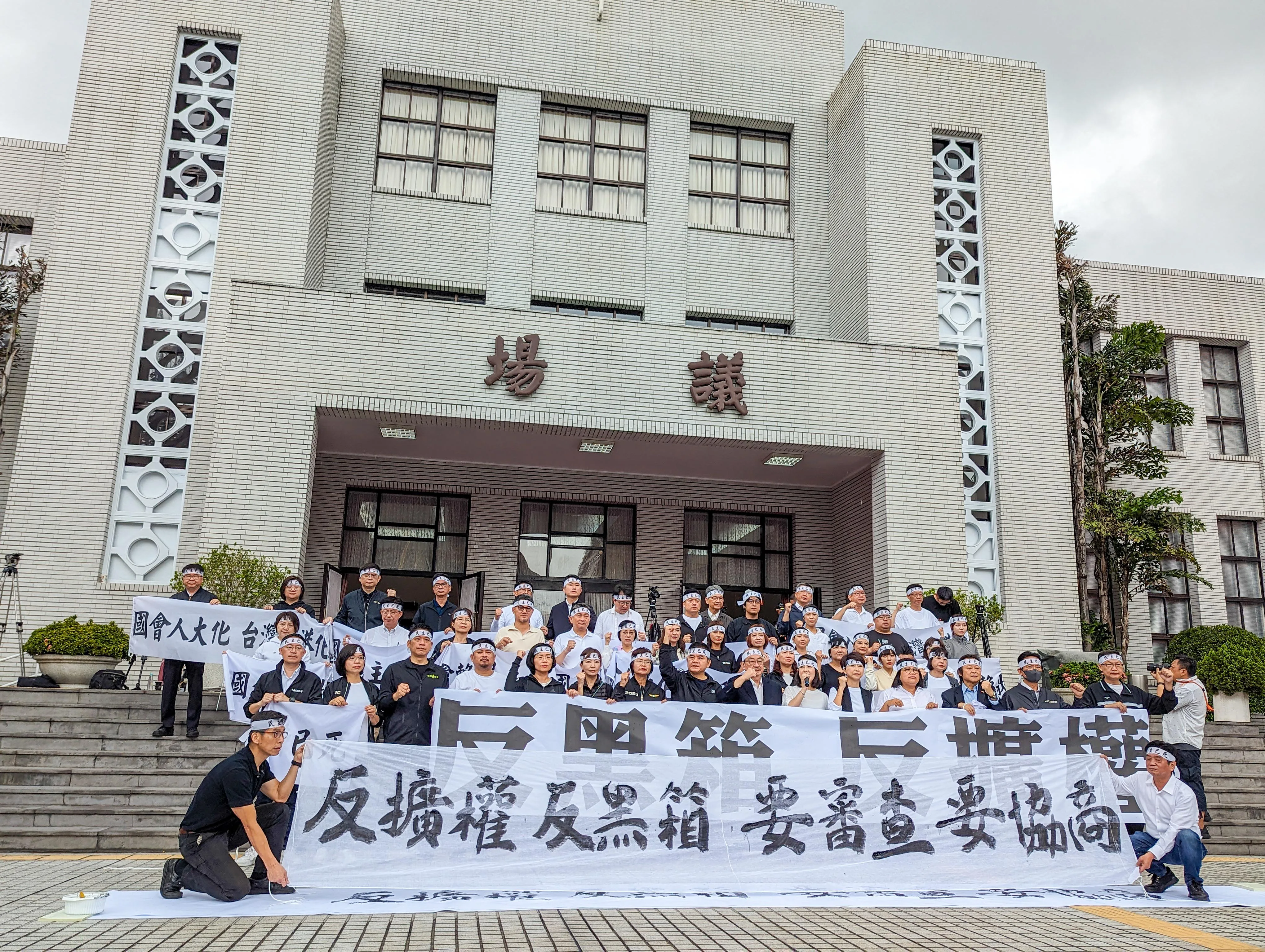 民進黨立委一早在議場外高舉布條抗議。