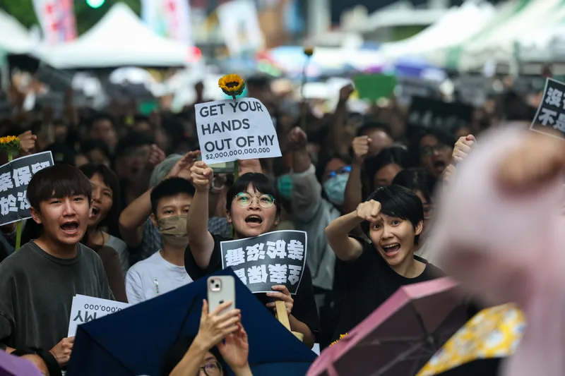 有民眾傍晚在立院大門外舉著標語抗議。中央社