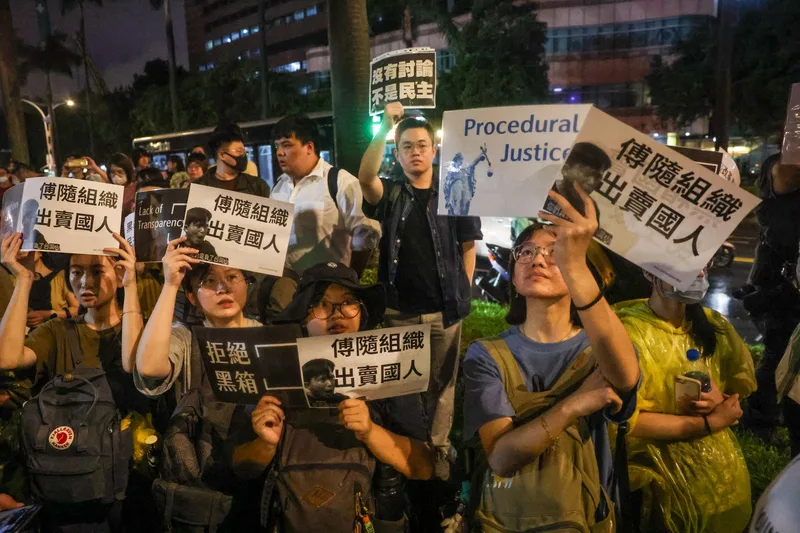 有民眾傍晚在立院大門外舉著標語抗議。中央社