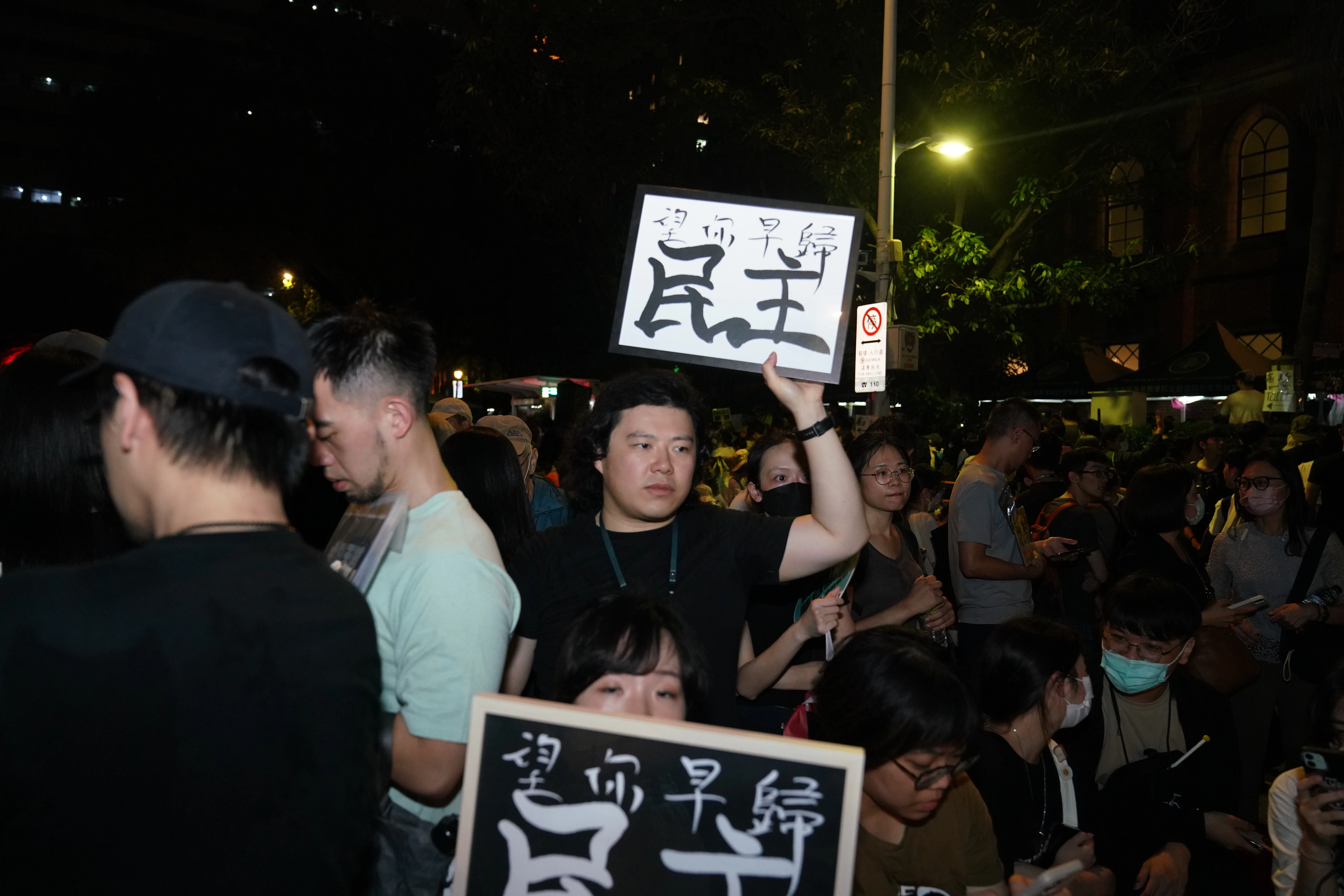 晚間8點前後，民眾持續舉著標語步入會場。李台源攝