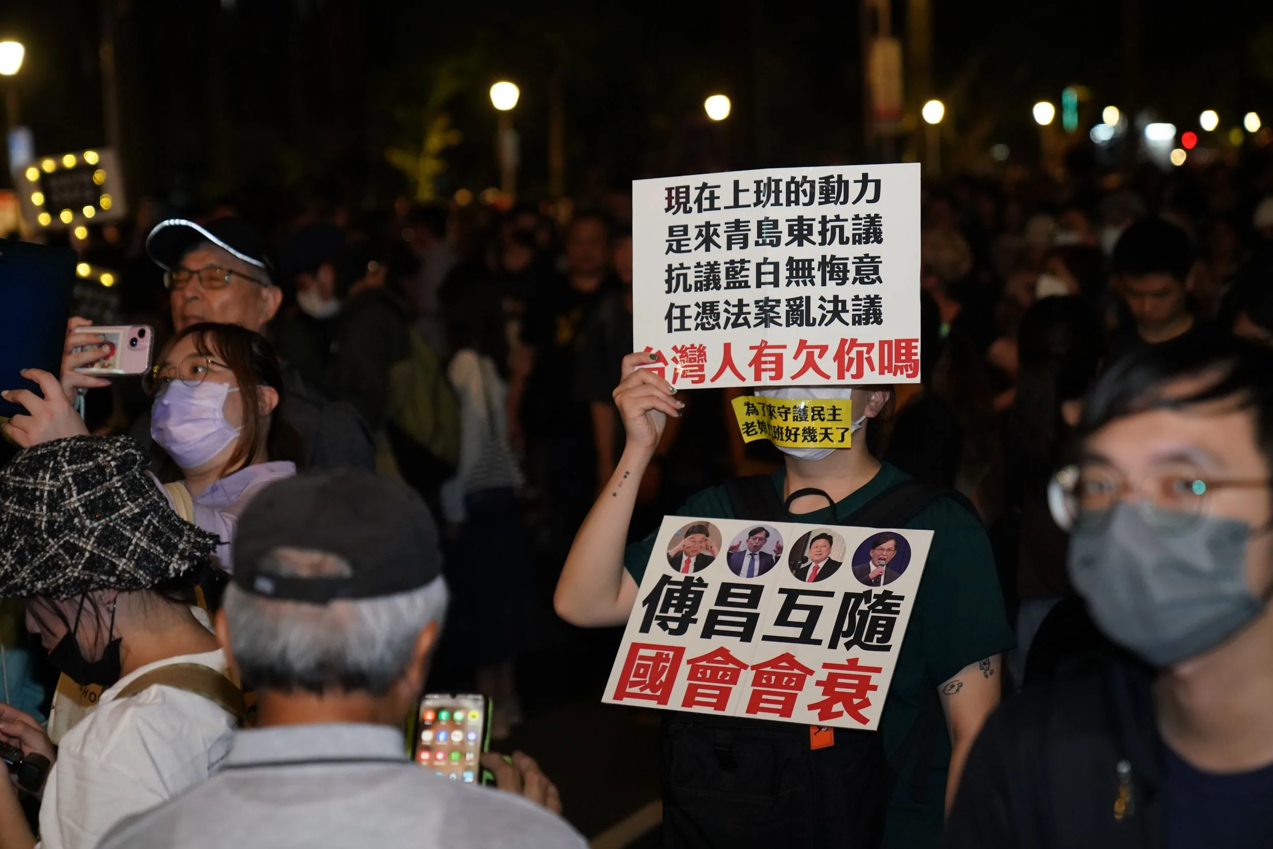 民眾高舉自製創意標語表達訴求。李台源攝