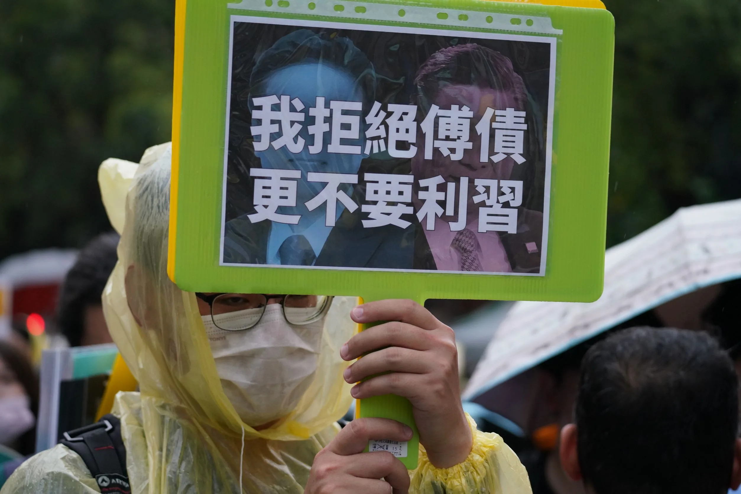 民眾冒雨於立法院外集結抗議。李台源攝