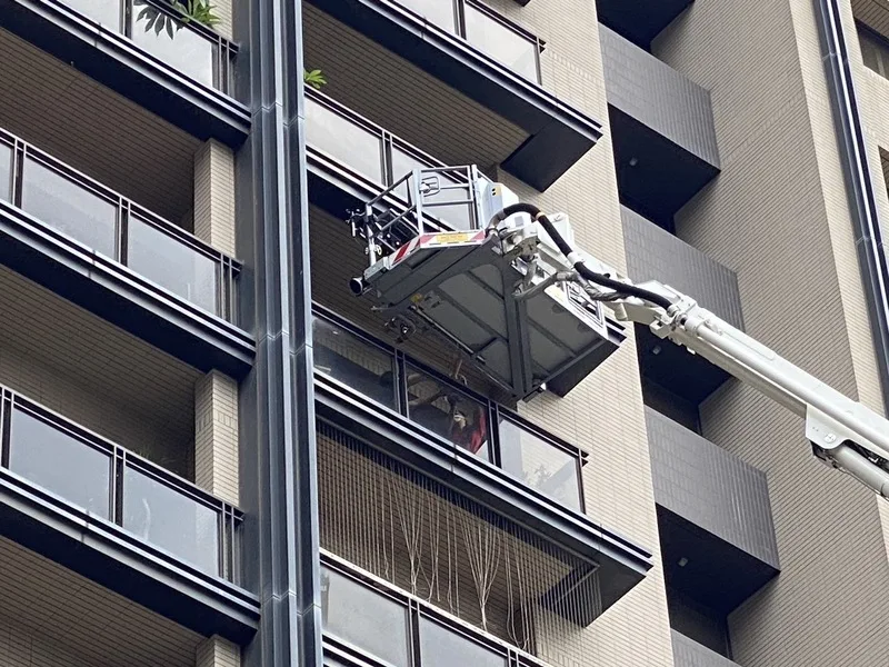 新竹市1棟集合式住宅26日發生火警,頂樓及各棟住戶仍有人待救,消防員使用雲梯車救出受困民眾。中央社
