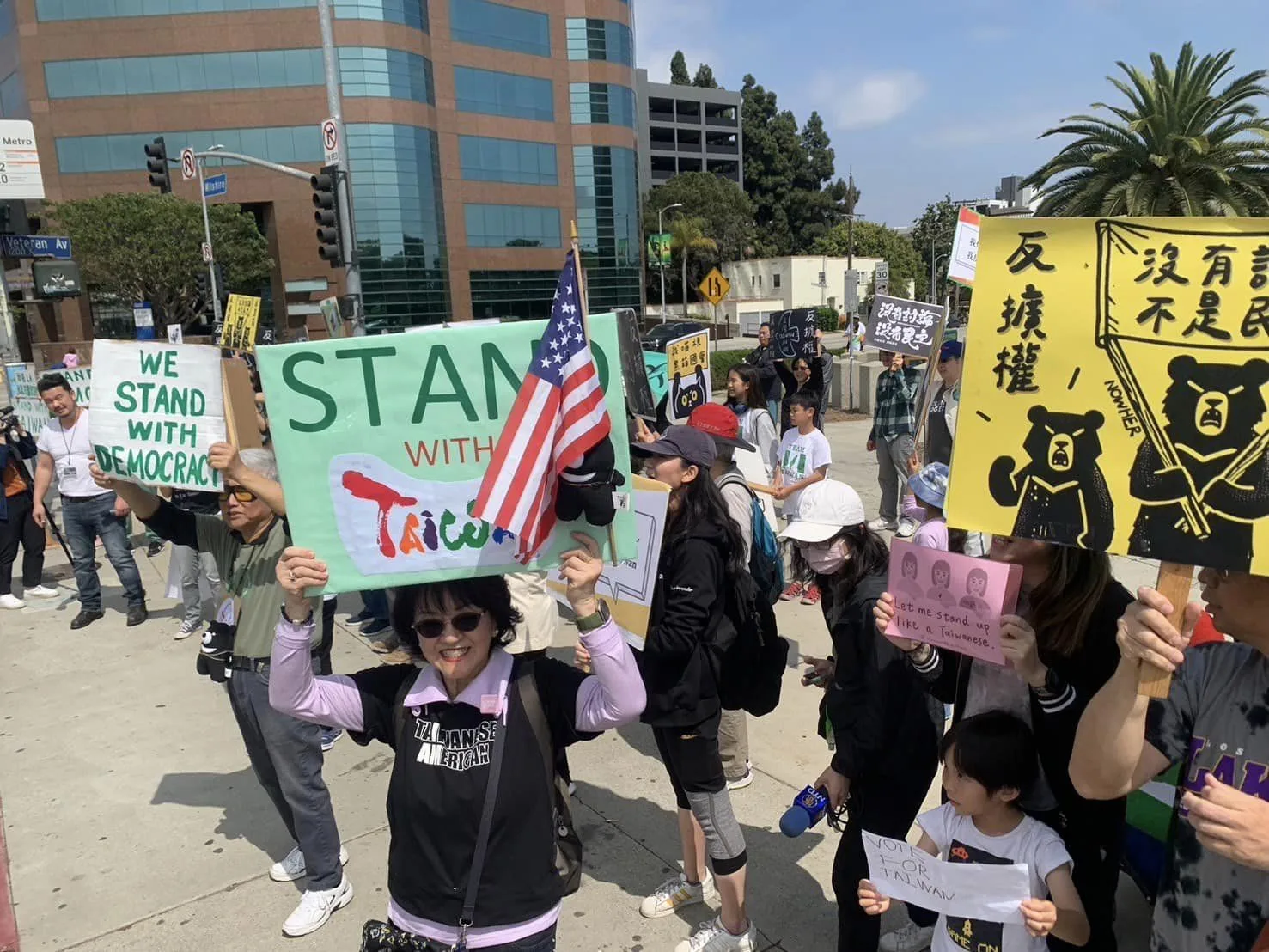 潘掬慧身穿「Taiwanese American」字樣T-Shirt,高舉「Stand with Taiwan」看板響應青鳥。翻攝美西台美人夏令會臉書