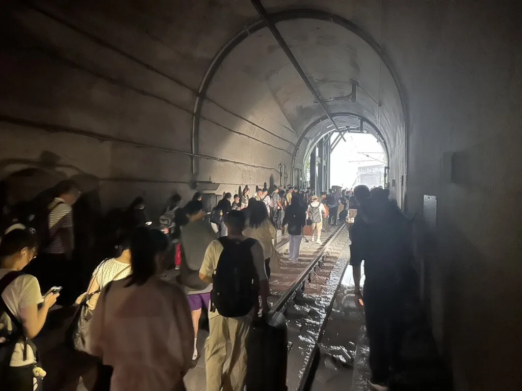 台鐵229班次新自強號疑撞擊落石,民眾下車步行離開隧道。民眾提供
