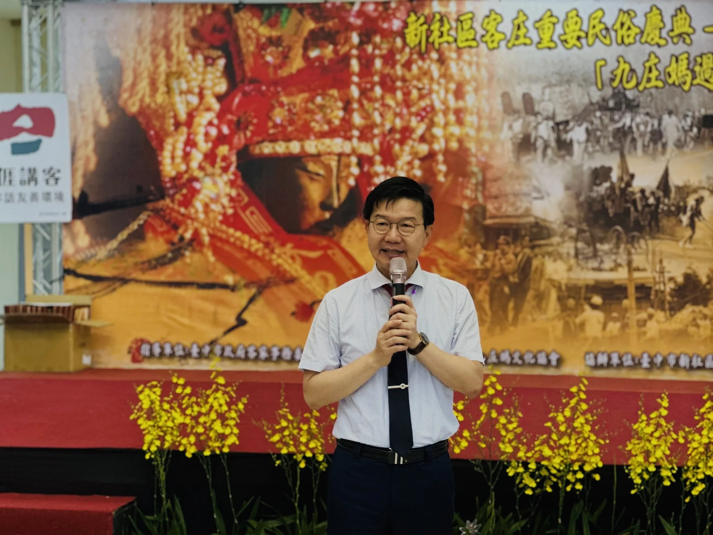 中市客委會主委江俊龍今26日在在新社區公所舉辦懷舊照片展致詞,邀請大家來看現場展出的100件有關九庄媽遶境的珍貴歷史照片。中市客委會提供