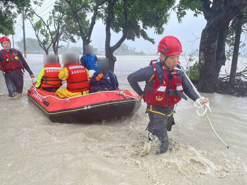 義縣豪雨強風不減,25日雨勢持續且逢大潮,八掌溪水暴漲溢堤,消防人員協助民眾脫困。嘉義縣消防局提供