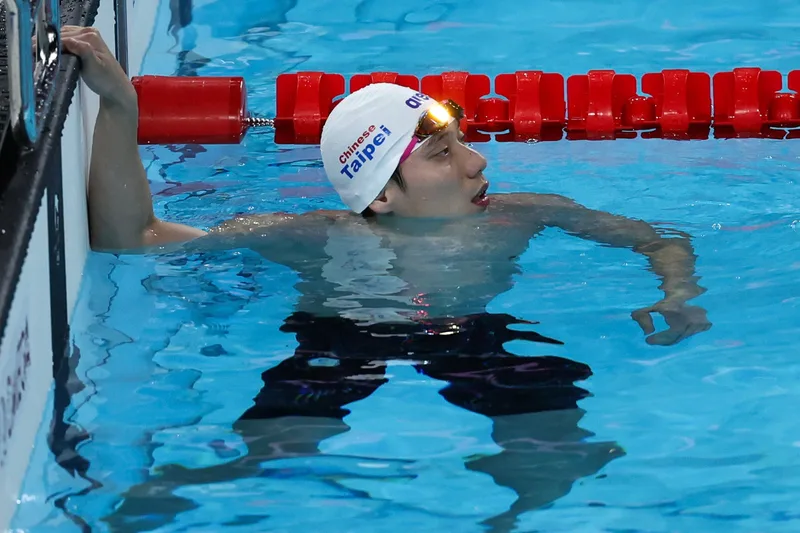 「台灣蝶王」王冠閎(圖)當地時間30日晚間征戰2024巴黎奧運游泳項目,在男子200公尺蝶式準決賽繳出1分55秒07的成績。王冠閎在終點觀看成績看板。中央社