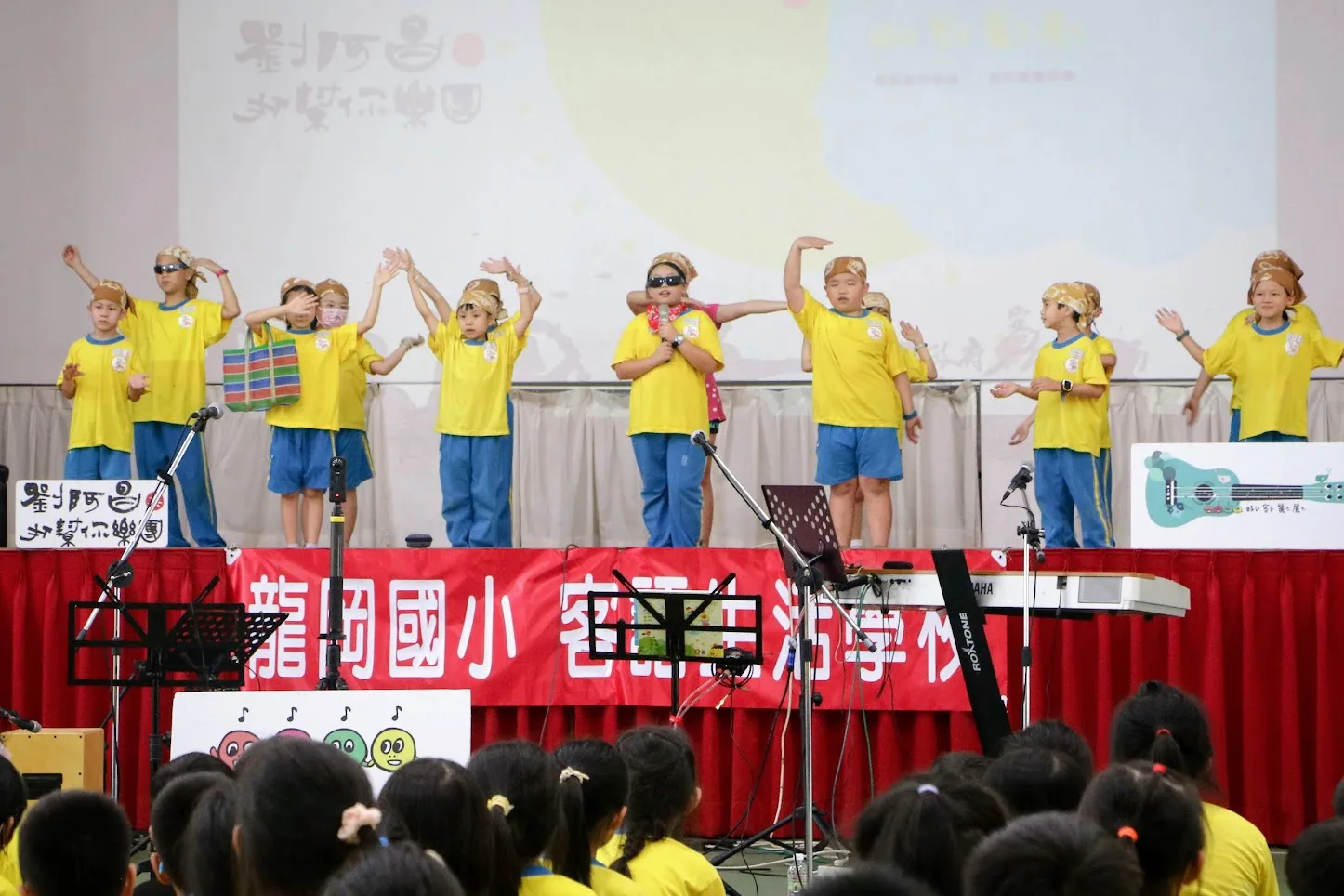 客家藝文社个小朋友，戴等烏目鏡，手擐等家濟袋仔，展出《客家阿婆》MV裡肚阿婆个造型。鍾孝昇攝