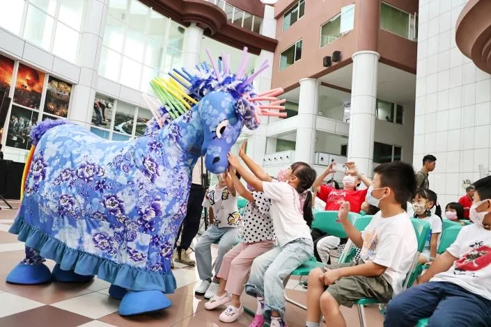 今(9)日台南市政府在永華市政中心舉辦《雨馬》台南演出宣傳記者會，小朋友看到小雨馬登場，開心地伸出手觸摸小雨馬。台南客委會提供